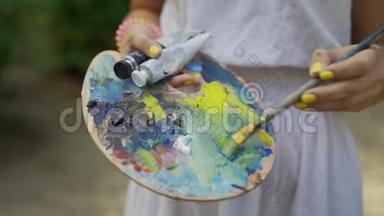 托盘上的女艺术家为4k的山水画铺上小颜料